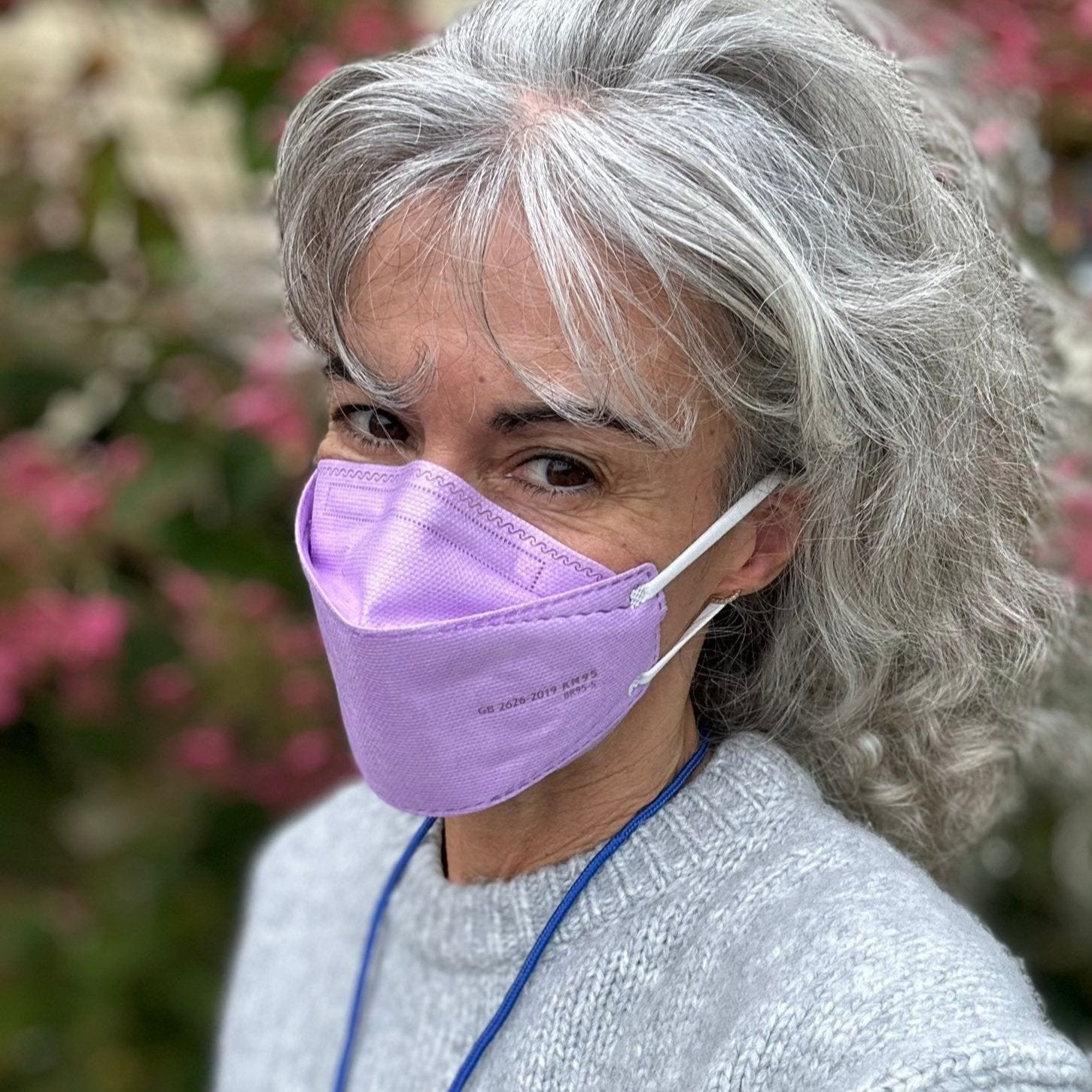 Teacher woman wearing medium purple lavender KN95 earloop respirator face mask breatheTeq USA made in Canada