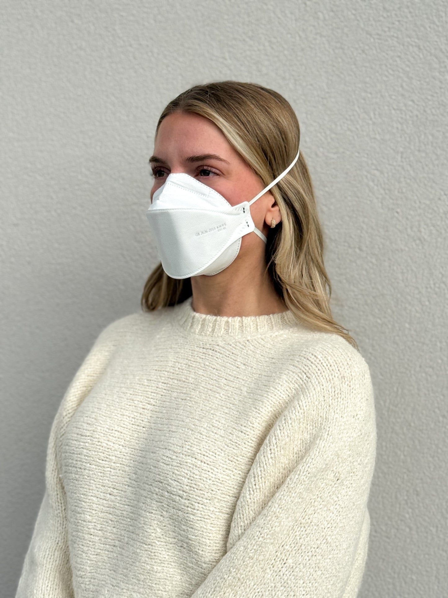 woman facing left wearing white KN95 breathable headband mask made by Breatheteq USA in Canada