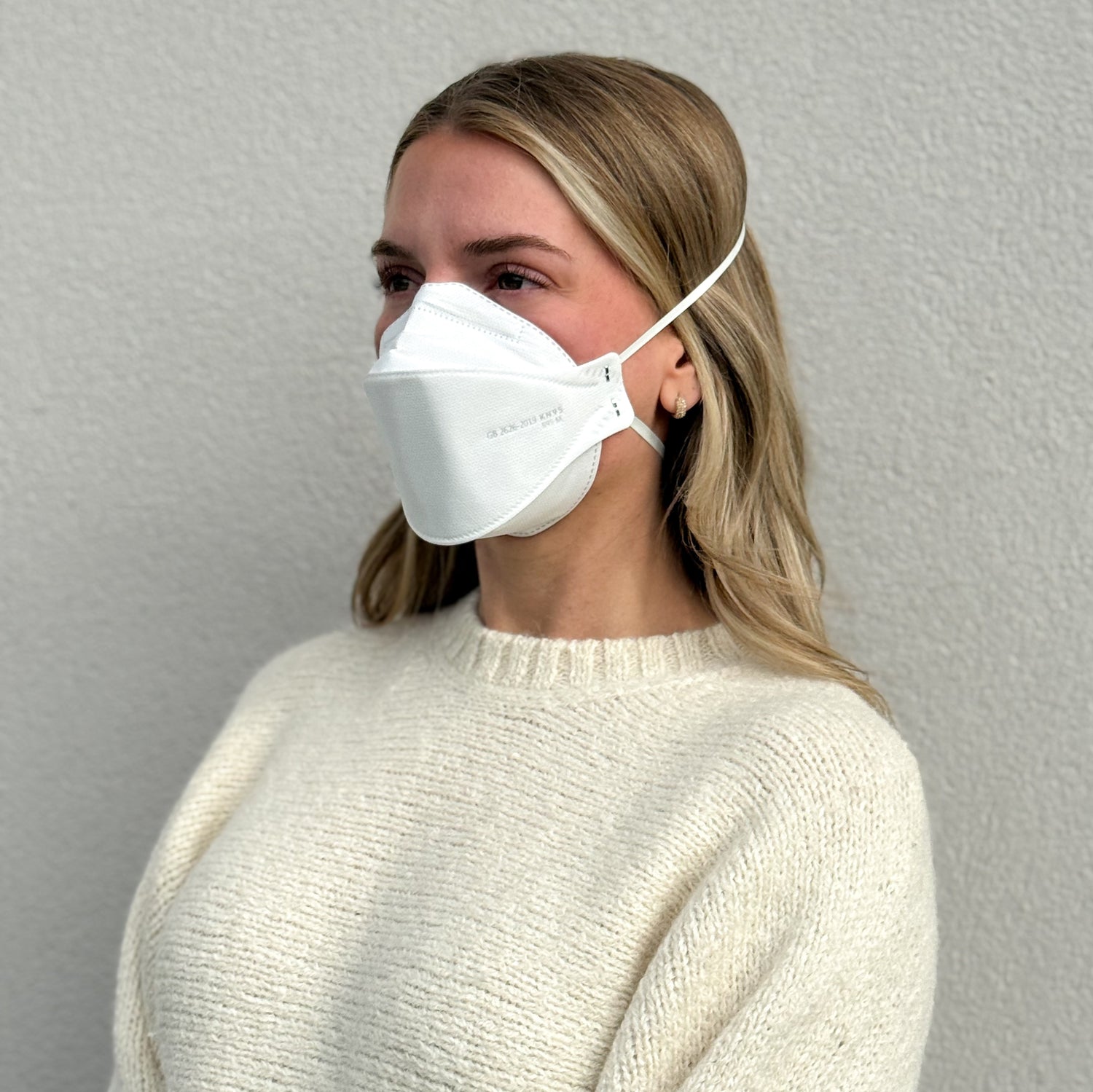 woman facing left wearing white KN95 breathable headband mask made by Breatheteq USA in Canada