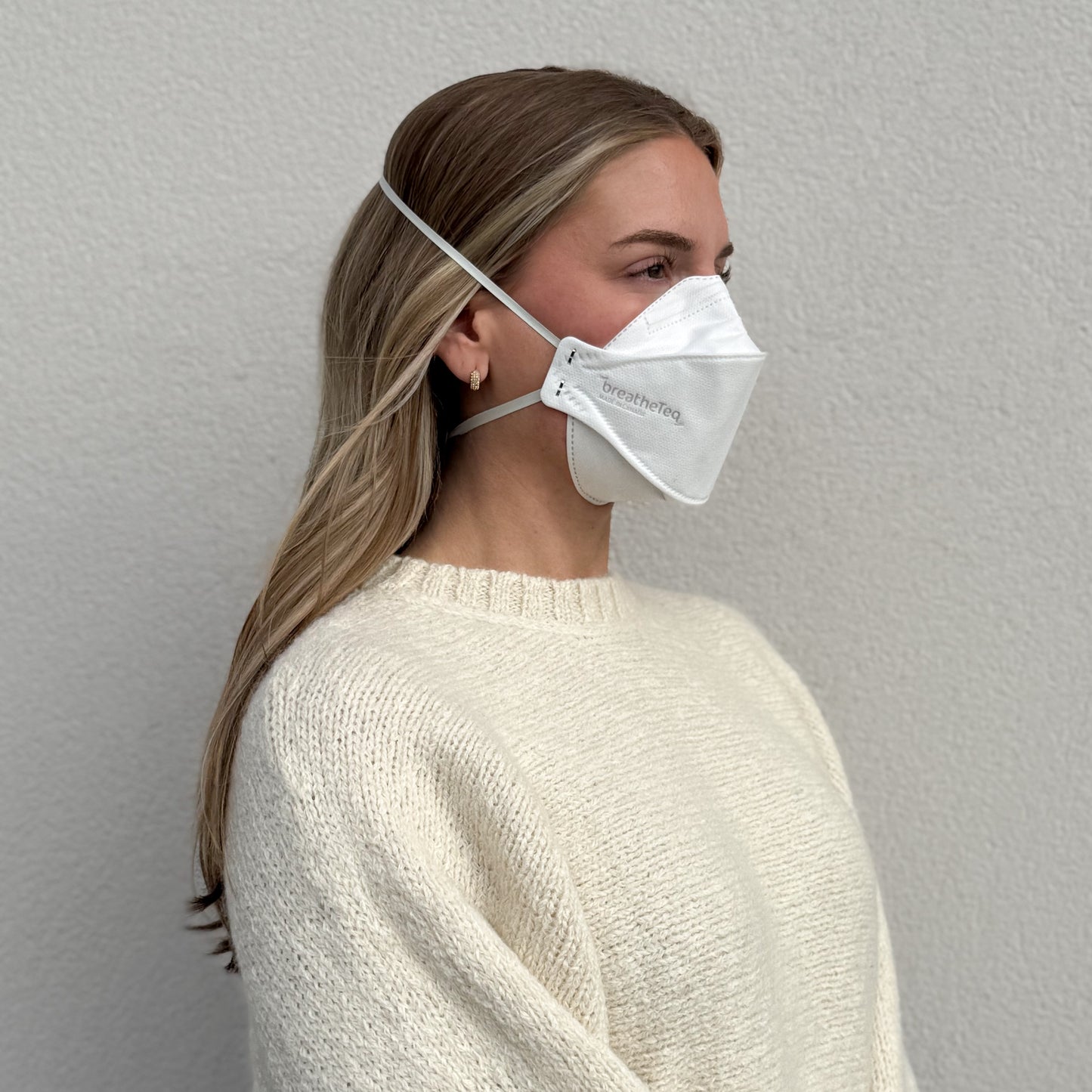 woman facing right wearing BreatheTeq white KN95 breathable headband mask - not NIOSH N95