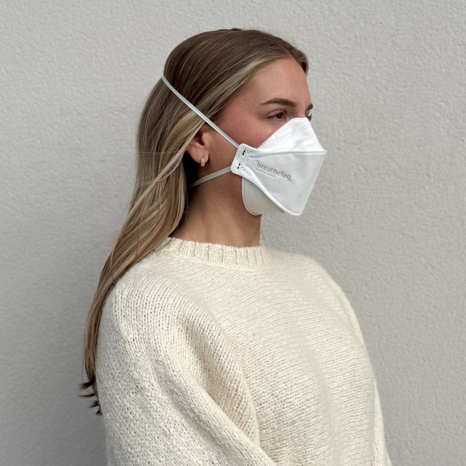 woman facing right wearing BreatheTeq white KN95 breathable headband mask - not NIOSH N95