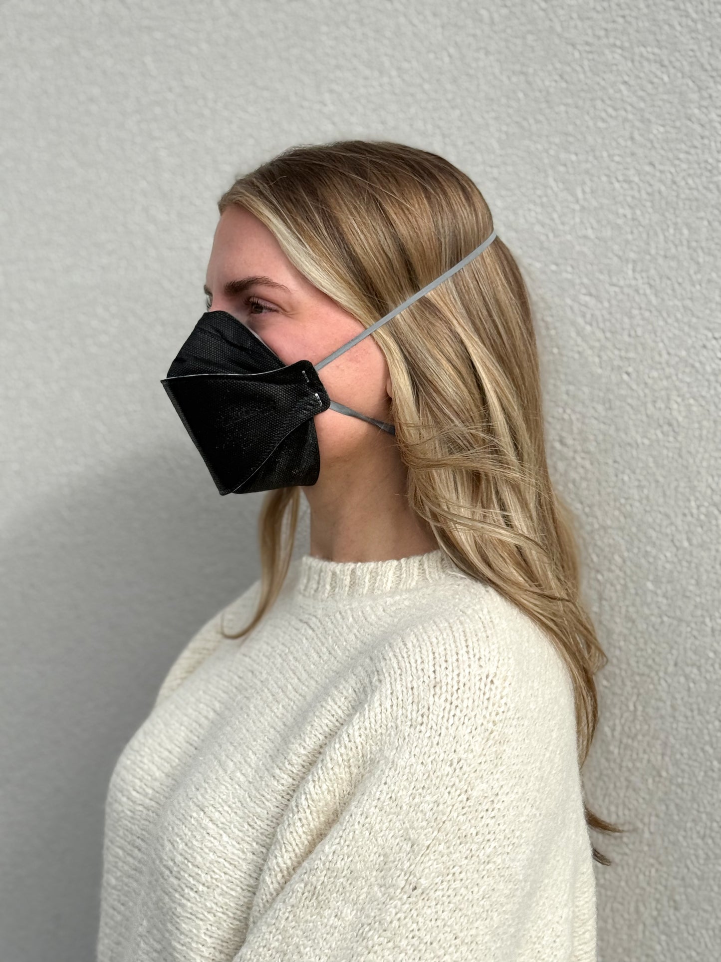woman facing right wearing breathable KN95 mask black not NIOSH N95 respirator made by Breatheteq