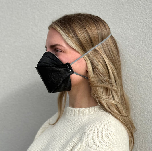 side view of woman with aura wearing breathable Breatheteq KN95 mask black not NIOSH N95 respirator