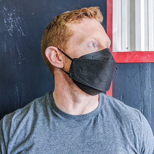 Man wearing XL extra large black breatheTeq KN95 earloop respirator mask made in Canada